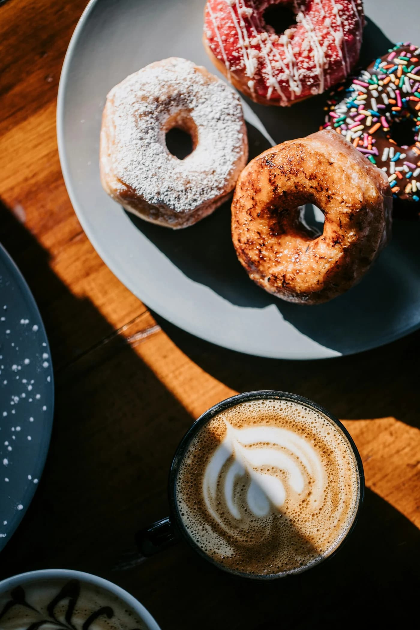 An illustrative café scene with coffee and assorted donuts